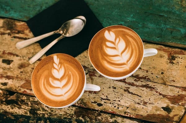 Deux tasses de café sur une planche de bois.