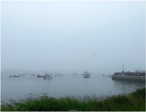 Des bateaux dans la brume sous le regard d'une procession à Saint-Pierre-et-Miquelon